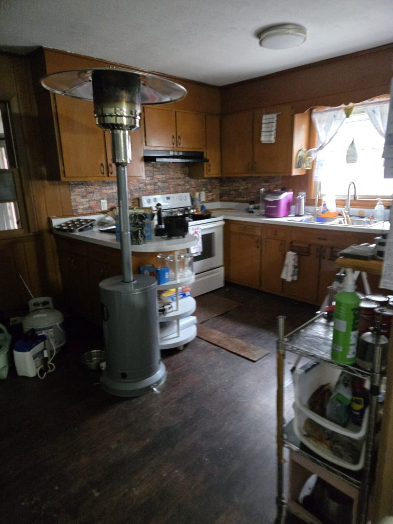 Dated kitchen with worn wood cabinets and cluttered countertops